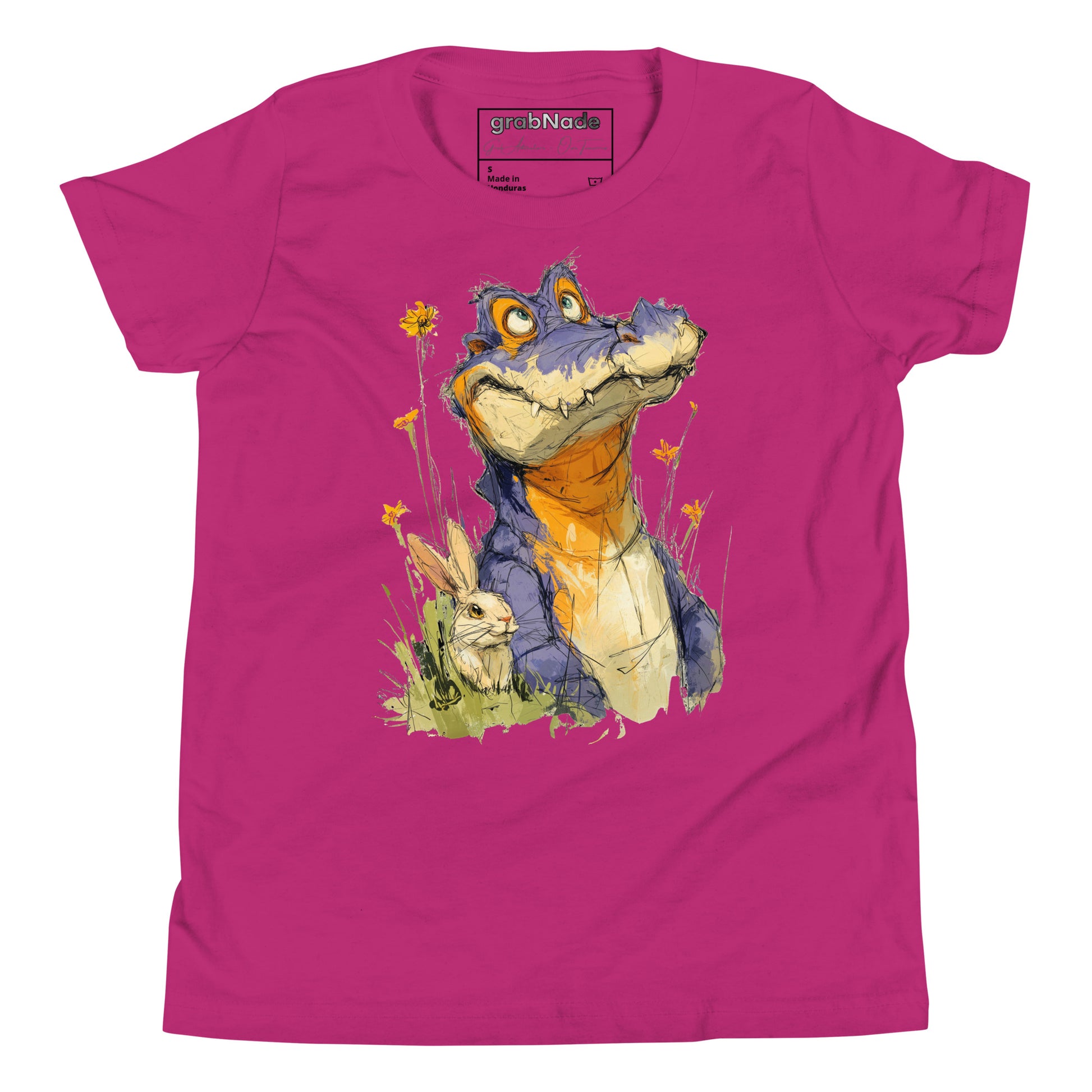 Product mockup. A playful, sketch-style illustration of a cheerful purple alligator with bright orange accents sitting in tall grass and wildflowers, accompanied by a white rabbit nestled by its side. Both characters feature expressive faces and are set against a plain pink t-shirt background, creating a whimsical and friendly scene.