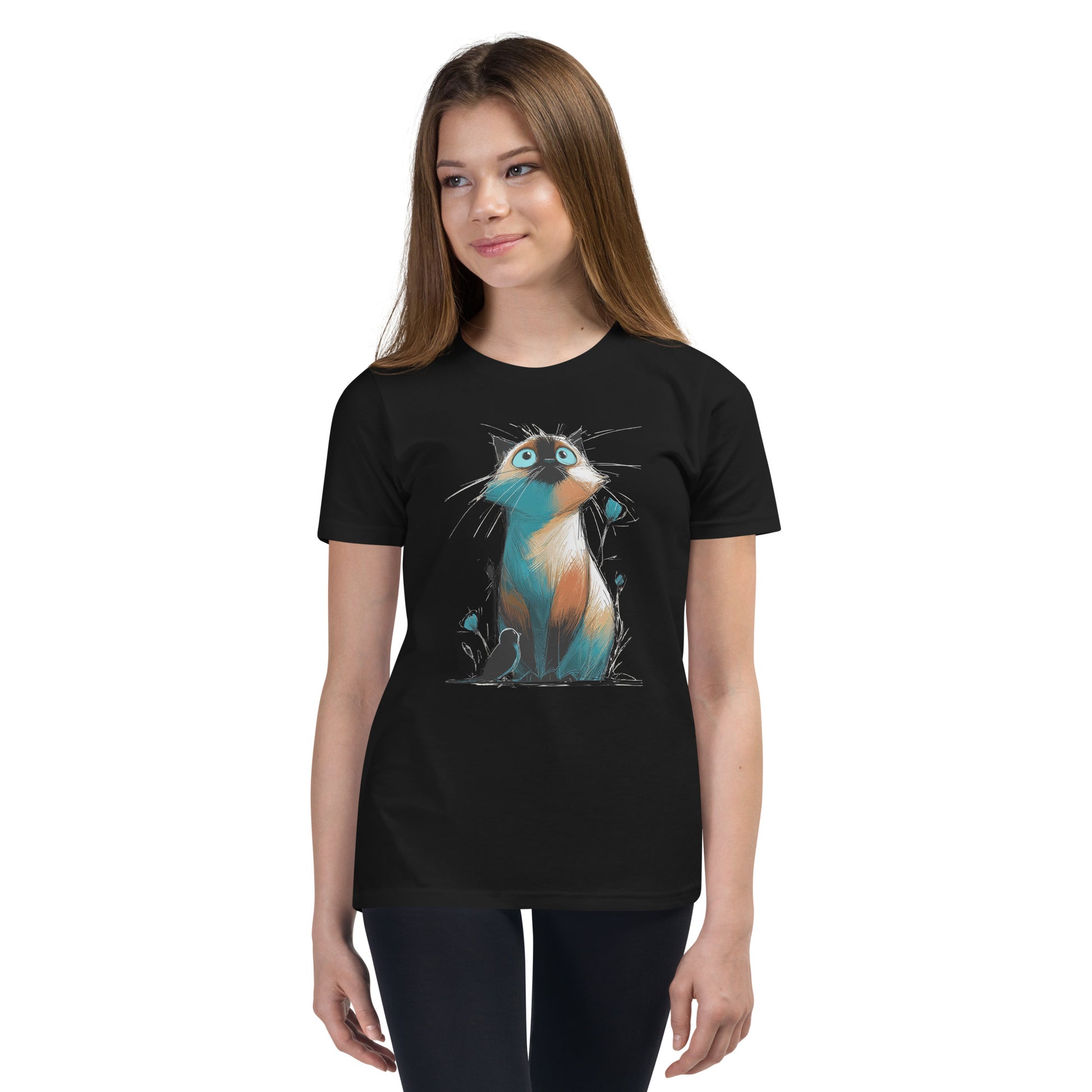 Product mockup. Ultra-soft premium youth black t-shirt featuring colorful artistic drawing of a wide-eyed cat sitting beside flowers and a black bird, modeled on young girl.