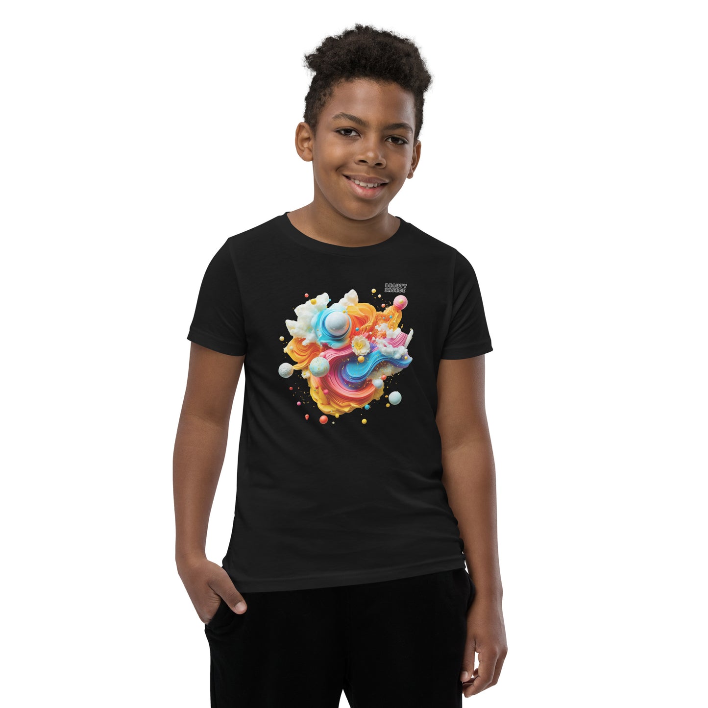 Product mockup. A young boy in a vibrant black t-shirt featuring a dynamic abstract design at the chest with swirling strokes of yellow, orange, pink, and blue, accented by playful 3D spheres, clouds, and flowers. Near the upper right area of the design, small white block text reads, 'BEAUTY INSIDE