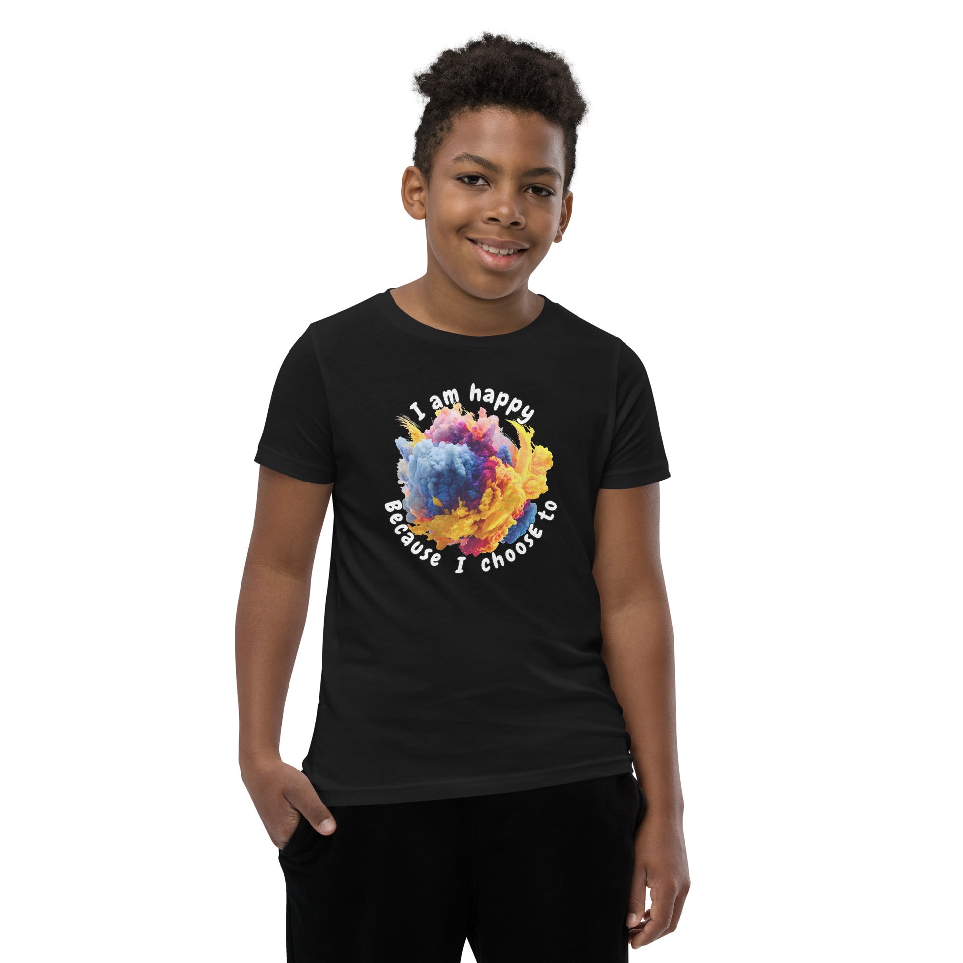 Product mockup. A smiling young boy wearing a black t-shirt with a colorful, cloud-like burst of blue, pink, purple, and yellow at the chest. Above and below the design, curved white text reads, 'I am happy Because I choose to,' in a playful, rounded font.