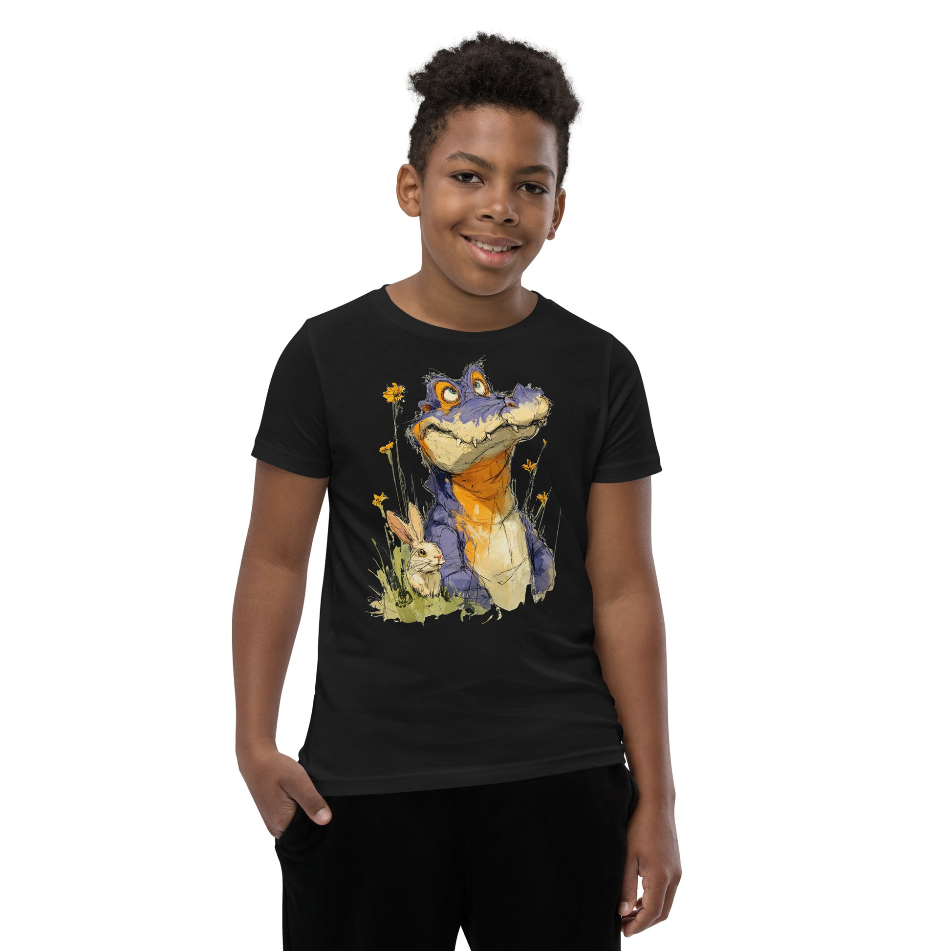 Product mockup.  A smiling child wearing a black t‑shirt featuring a whimsical sketch of a purple alligator with orange accents sitting in tall grass beside a white rabbit and yellow wildflowers, set against a clean studio background.