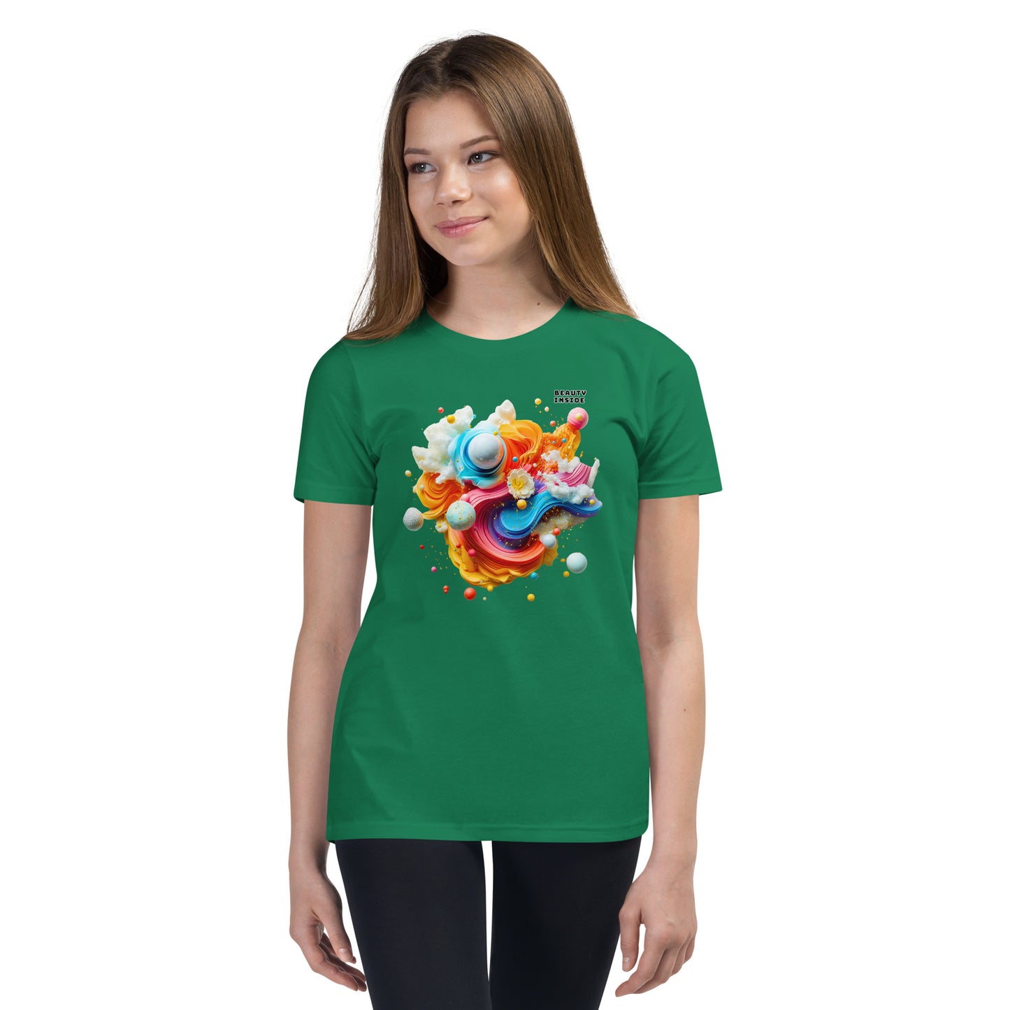 Product mockup. A young girl wearing a green youth ultra-soft premium t-shirt with a colorful, abstract modern art design on the front. The design includes vibrant swirls and spheres in blue, pink, orange, yellow, and white, with a small 'BEAUTY INSIDE' text near the upper right part of the graphic. She is paired with black leggings and looking slightly to the side with a subtle smile.