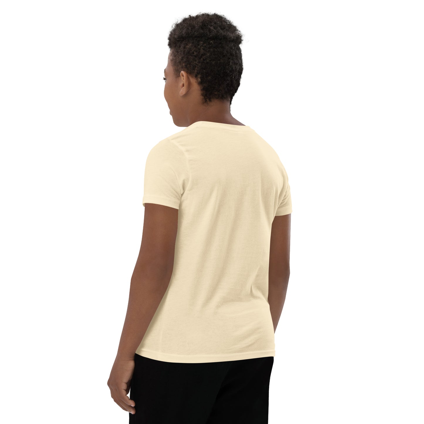 Product mockup. A boy shown from behind wearing a plain beige, short-sleeve t-shirt and black pants. His curly hair is closely cropped, and the back of the shirt is blank with no visible design or graphics.