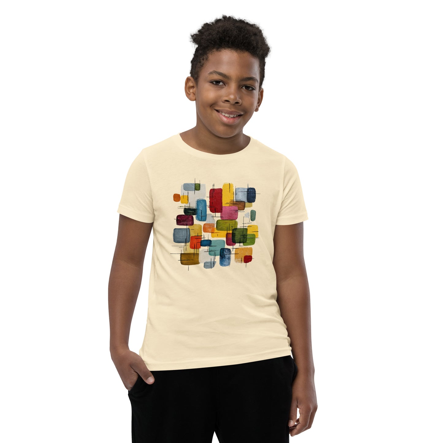 Product mockup. A young man wearing a beige, short-sleeve t-shirt with a large, colorful abstract design on the front. The design features overlapping rounded rectangles in red, yellow, teal, blue, green, and orange, with fine black sketch lines, creating a playful and modern look. She is also wearing black leggings.