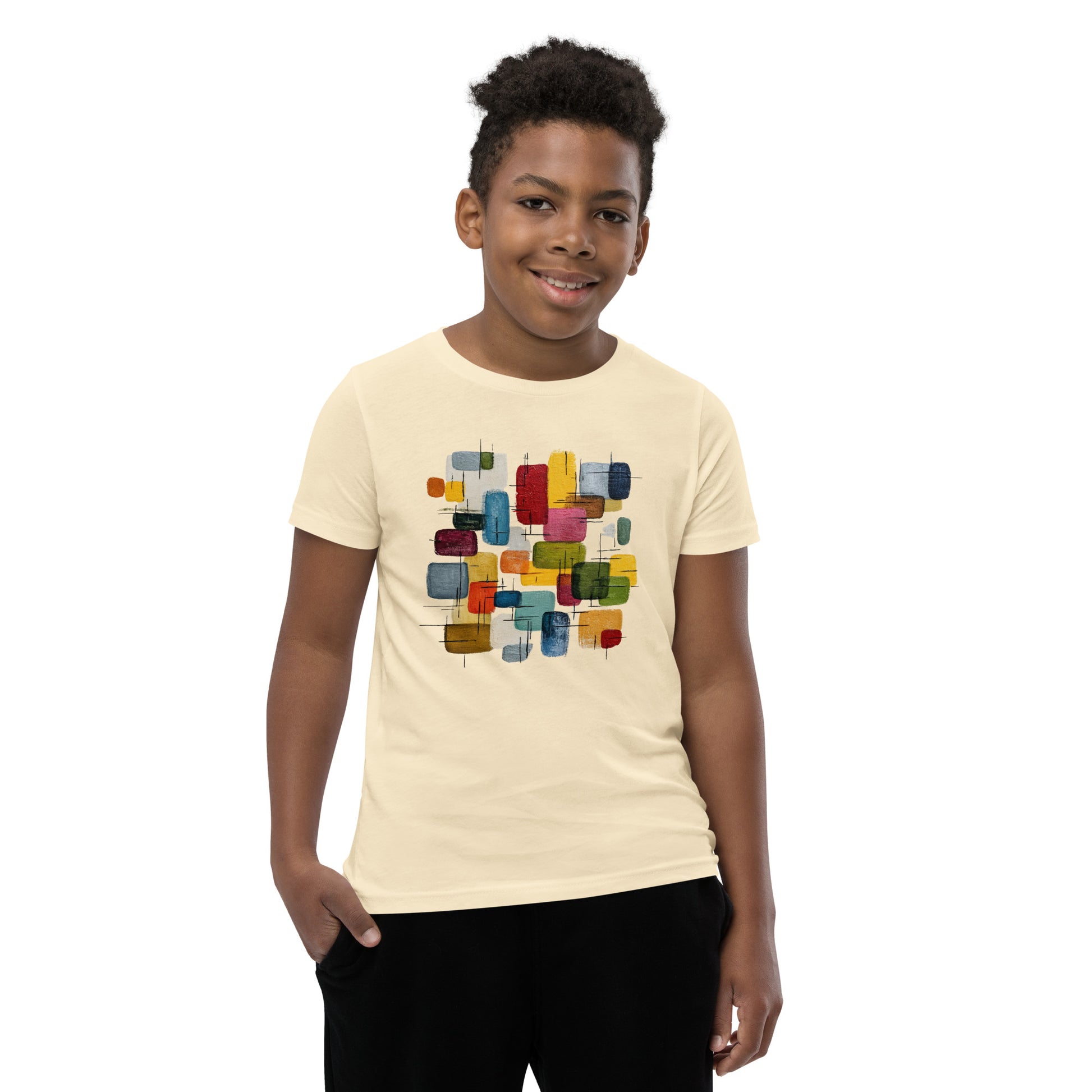 Product mockup. A young man wearing a beige, short-sleeve t-shirt with a large, colorful abstract design on the front. The design features overlapping rounded rectangles in red, yellow, teal, blue, green, and orange, with fine black sketch lines, creating a playful and modern look. She is also wearing black leggings.