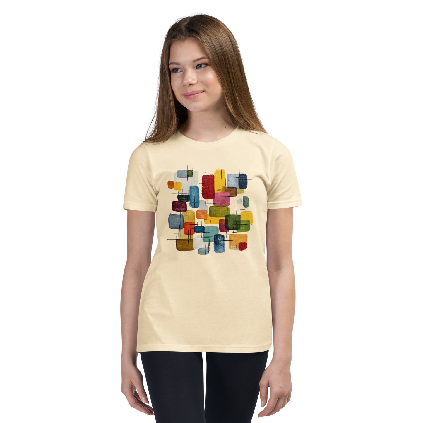 Product mockup. A young woman wearing a beige, short-sleeve t-shirt with a large, colorful abstract design on the front. The design features overlapping rounded rectangles in red, yellow, teal, blue, green, and orange, with fine black sketch lines, creating a playful and modern look. She is also wearing black leggings.