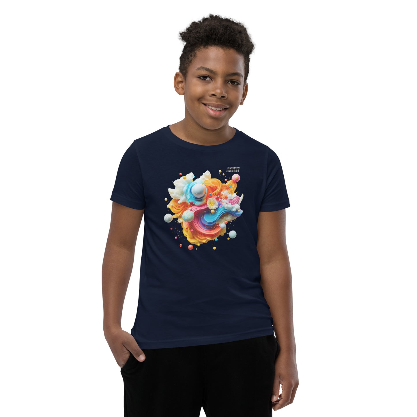 Product mockup. A young boy in a vibrant navy blue t-shirt featuring a dynamic abstract design at the chest with swirling strokes of yellow, orange, pink, and blue, accented by playful 3D spheres, clouds, and flowers. Near the upper right area of the design, small white block text reads, 'BEAUTY INSIDE