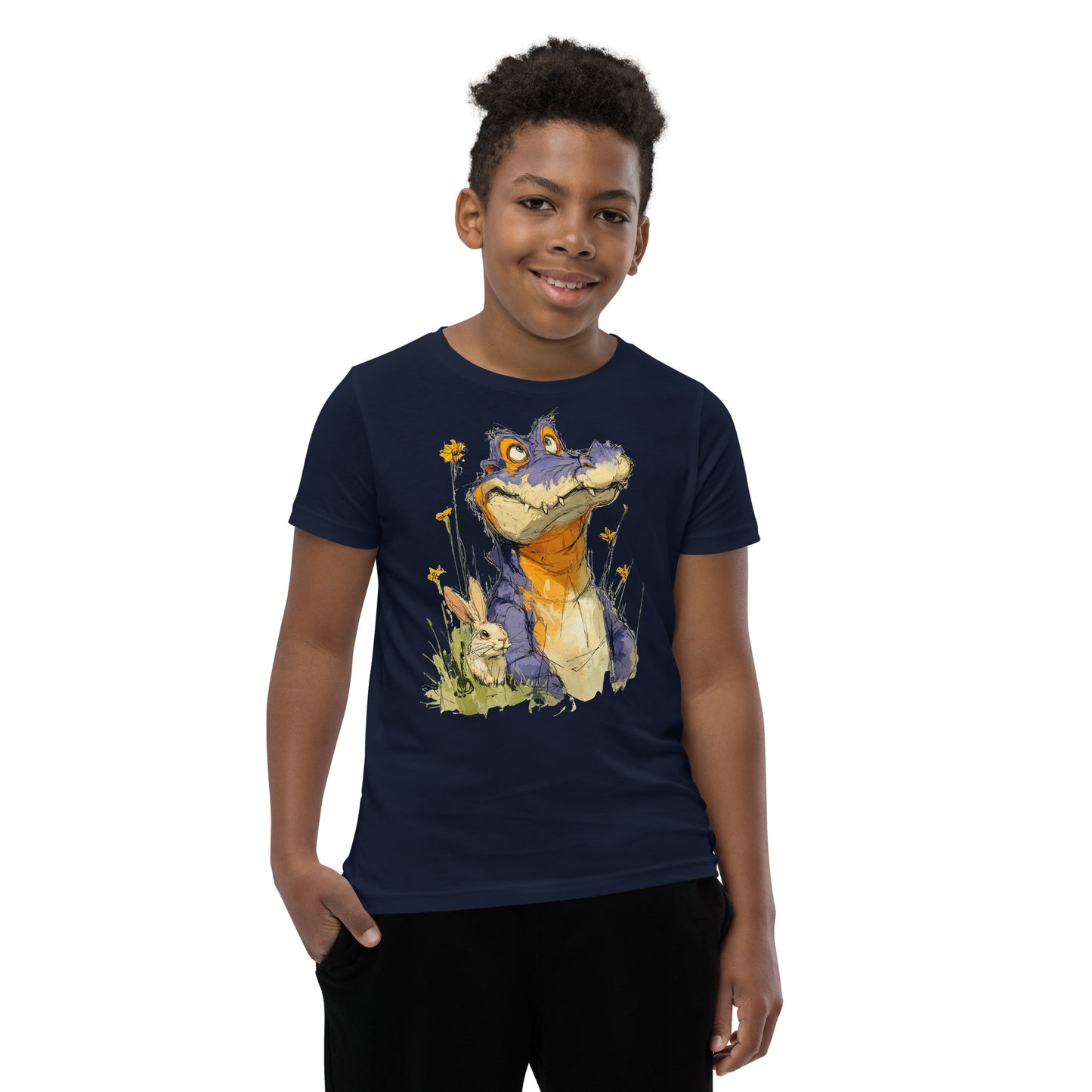 Product mockup.  A smiling child wearing a navy-blue t‑shirt featuring a whimsical sketch of a purple alligator with orange accents sitting in tall grass beside a white rabbit and yellow wildflowers, set against a clean studio background.
