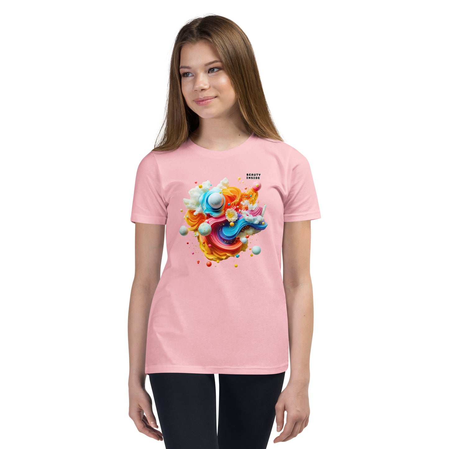 Product mockup. A young girl wearing a pink youth ultra-soft premium t-shirt with a colorful, abstract modern art design on the front. The design includes vibrant swirls and spheres in blue, pink, orange, yellow, and white, with a small 'BEAUTY INSIDE' text near the upper right part of the graphic. She is paired with black leggings and looking slightly to the side with a subtle smile.