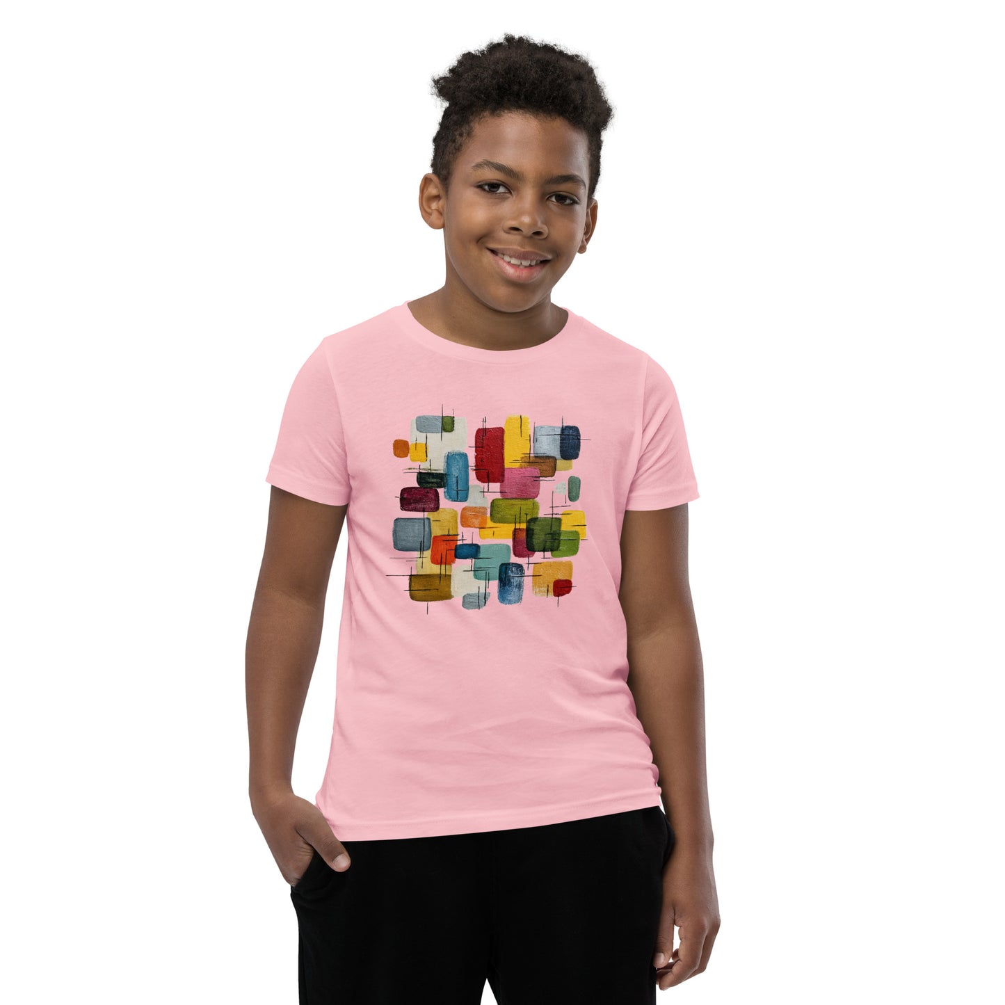 Product mockup. A young man wearing a light pink, short-sleeve t-shirt with a large, colorful abstract design on the front. The design features overlapping rounded rectangles in red, yellow, teal, blue, green, and orange, with fine black sketch lines, creating a playful and modern look. She is also wearing black leggings.