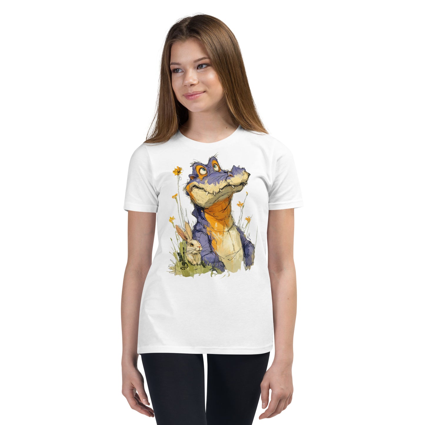 Product mockup. Ultra-soft premium youth white t-shirt featuring whimsical colorful illustration of a playful purple and orange alligator sitting in grass next to a small rabbit and yellow wildflowers, modeled on young girl.