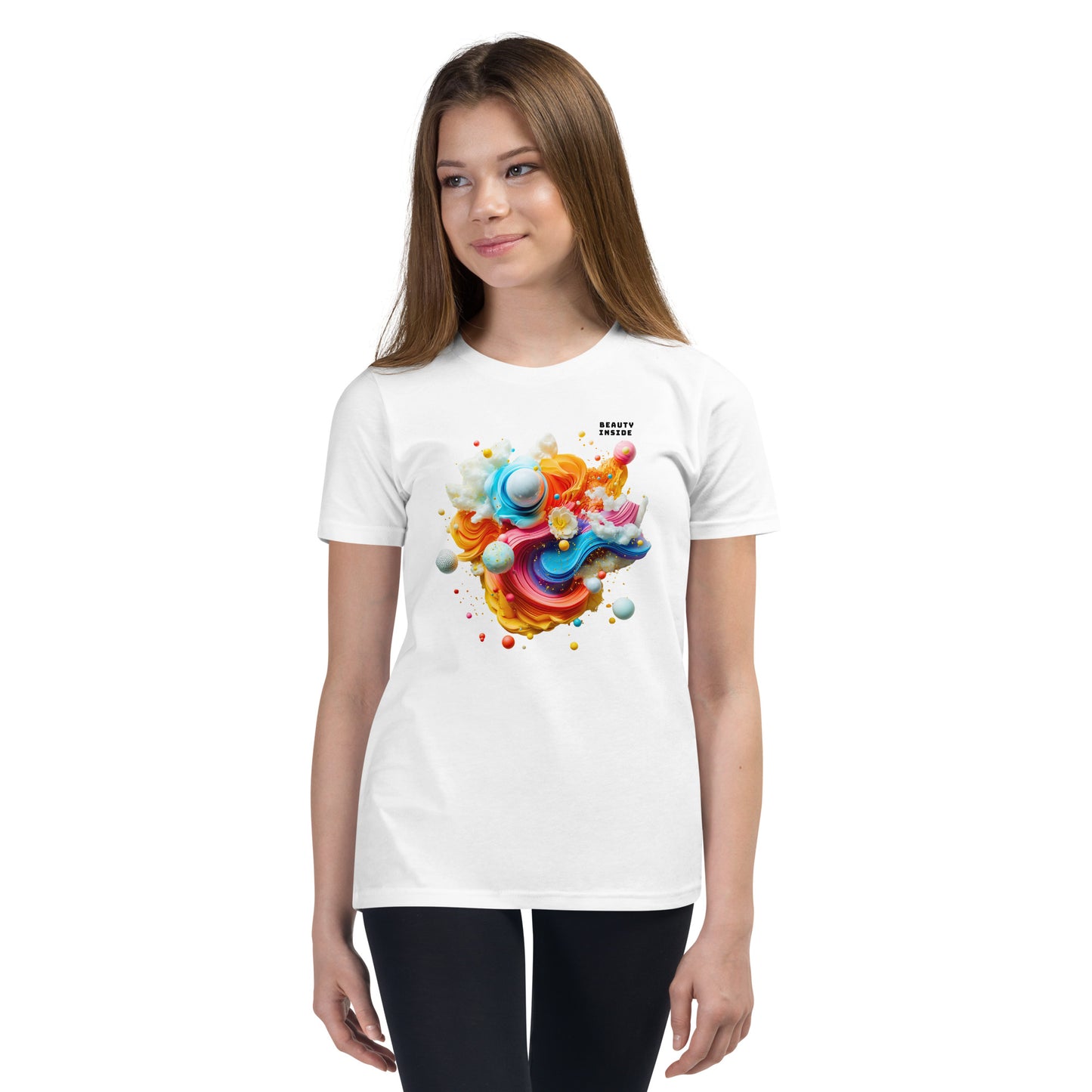 Product mockup. A young girl wearing a white youth ultra-soft premium t-shirt with a colorful, abstract modern art design on the front. The design includes vibrant swirls and spheres in blue, pink, orange, yellow, and white, with a small 'BEAUTY INSIDE' text near the upper right part of the graphic. She is paired with black leggings and looking slightly to the side with a subtle smile.